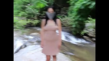 Beautiful young woman with big breasts exposed in three o'clock photo at waterfall